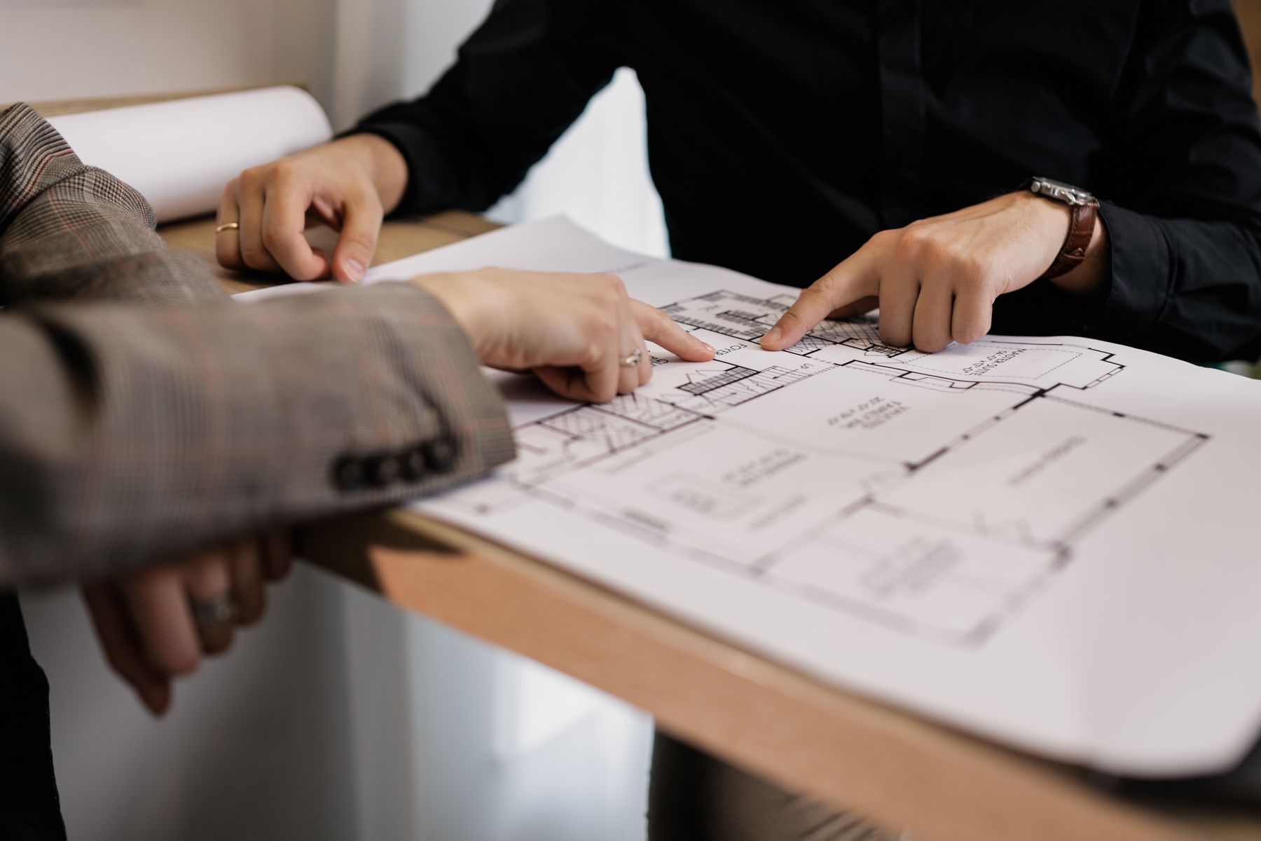 People pointing at a floor plan during a document review