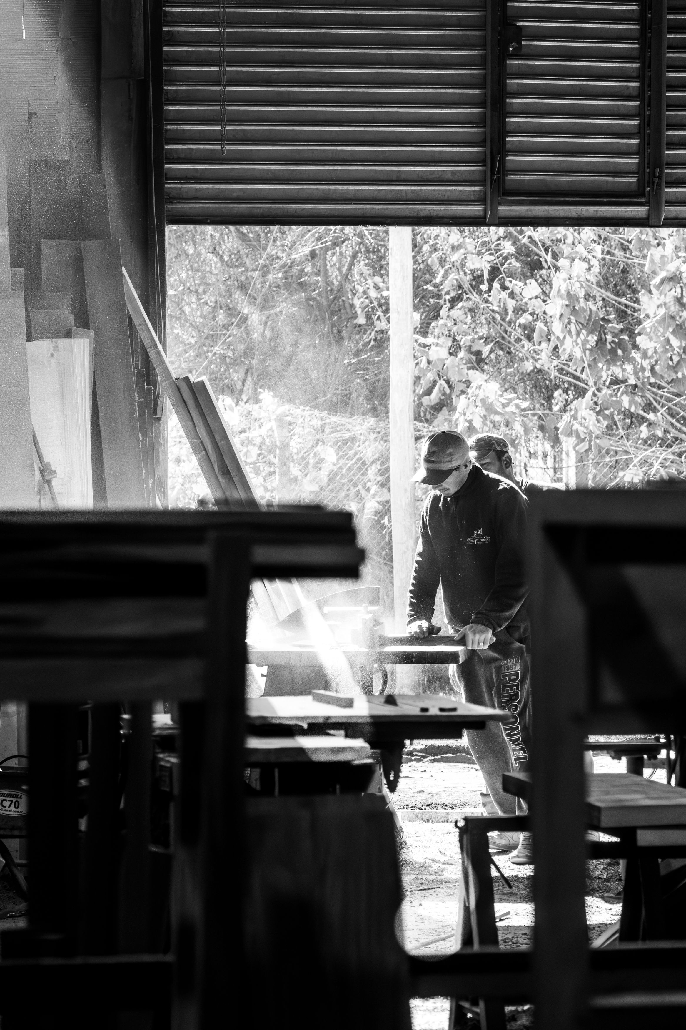 Woodworker operating machinery in a sunlit workshop